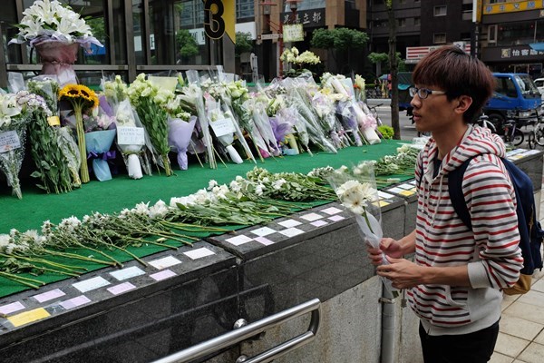 民众到站外献白花吊慰亡灵