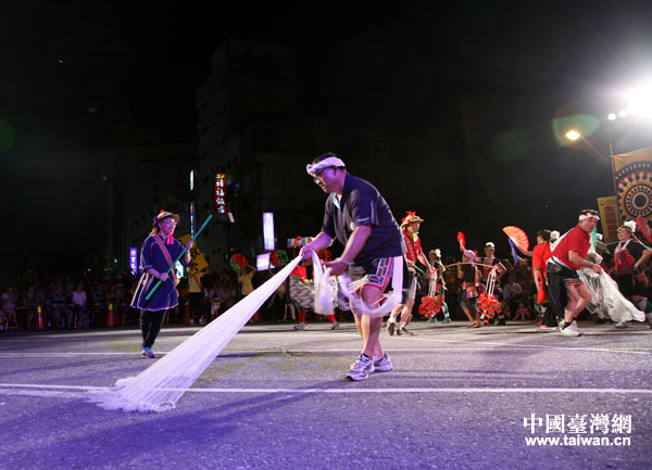 参加丰年祭“踩街”活动台湾少数民族参演团队在表演捕鱼生活场景