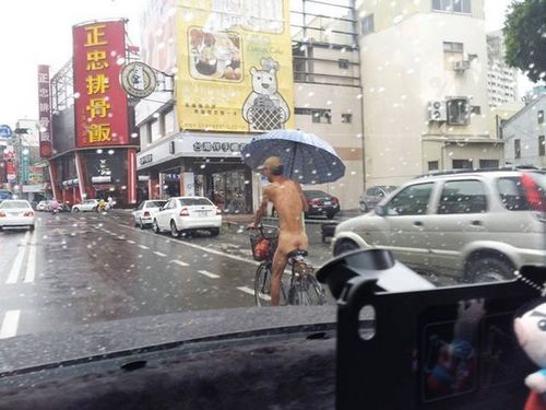 男子全裸骑车还撑伞网友笑称“多此一举”（图）