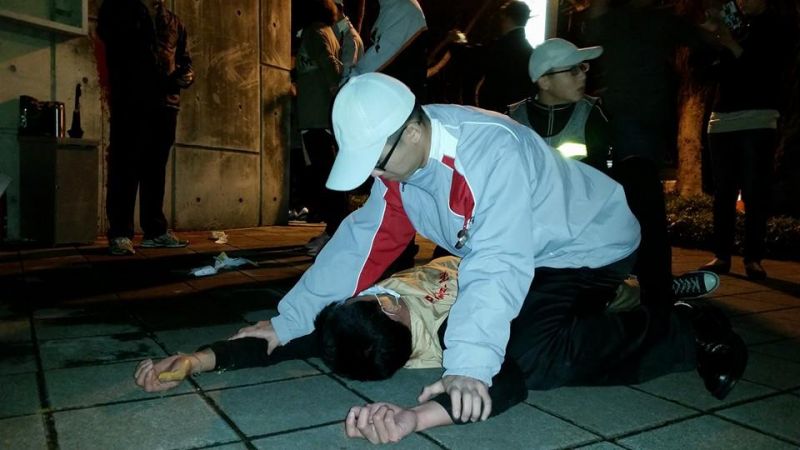 “台联青年军”27日夜袭马英九官邸泼漆，图为维安人员将一名抗议者扑倒在地，网友戏称“地板咚”