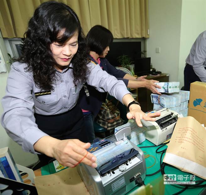 台南市议长李全教裁定以新台币1500万元交保，亲友拿着钱前来缴交。