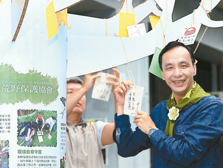　　国民党2016参选人朱立伦（右）昨天拜访荒野保护协会，并在许愿树上留下“永续台湾、生态之岛”的祝福。（《联合报》 王腾毅摄）
