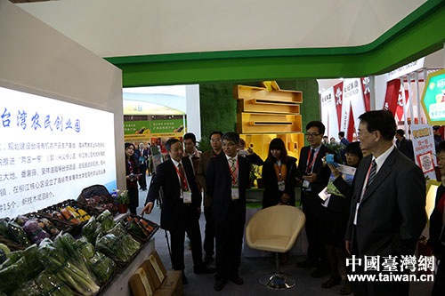 四川省台办主任周敏谦（左一）向台湾农业参访团嘉宾介绍展览情况。