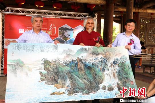 台湾著名画家王太田(中)与台湾导报社长林文雄(左)向海峡之声广播电台副总编郭红斌赠画。　黄少华 摄
