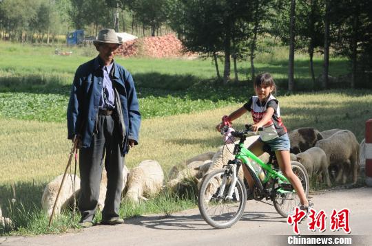 图为陈萱2009年骑行丝路途中和牧羊老人合影。　陈守忠提供 摄