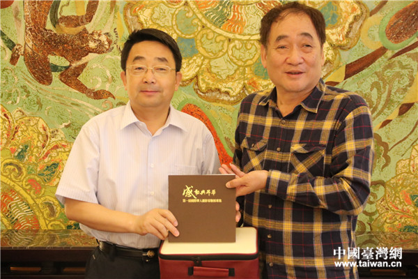 台湾摄影家交流协会理事长林再生（右）向甘肃省台办主任王锋赠送礼物。（中国台湾网 刘燕莱 摄）