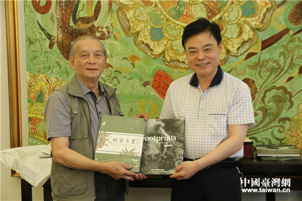 世界华人摄影学会副会长翁庭华（左）向甘肃省文联副主席李积麒赠送礼物。（中国台湾网 刘燕莱 摄）