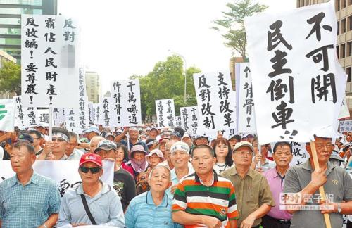 全台农田水利会“反延任反改制自救会”5日在“立法院”外抗议，农民举标语喊“官派会长，民主倒退”口号。(图片来源：台湾《中时电子报》)