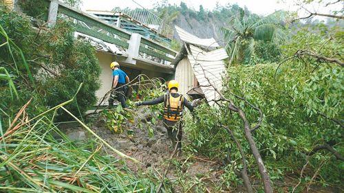 高雄市施福寅一家三口疑遭土石流掩埋,警消搜救人员冒险进入施宅搜救。来源:台湾《联合报》(高雄市消防局提供)